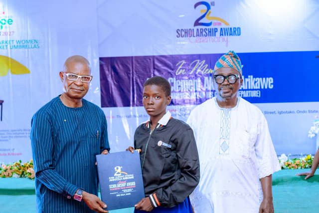 Rewarding science excellence: A top female student is presented with her scholarship folder by dignitaries.